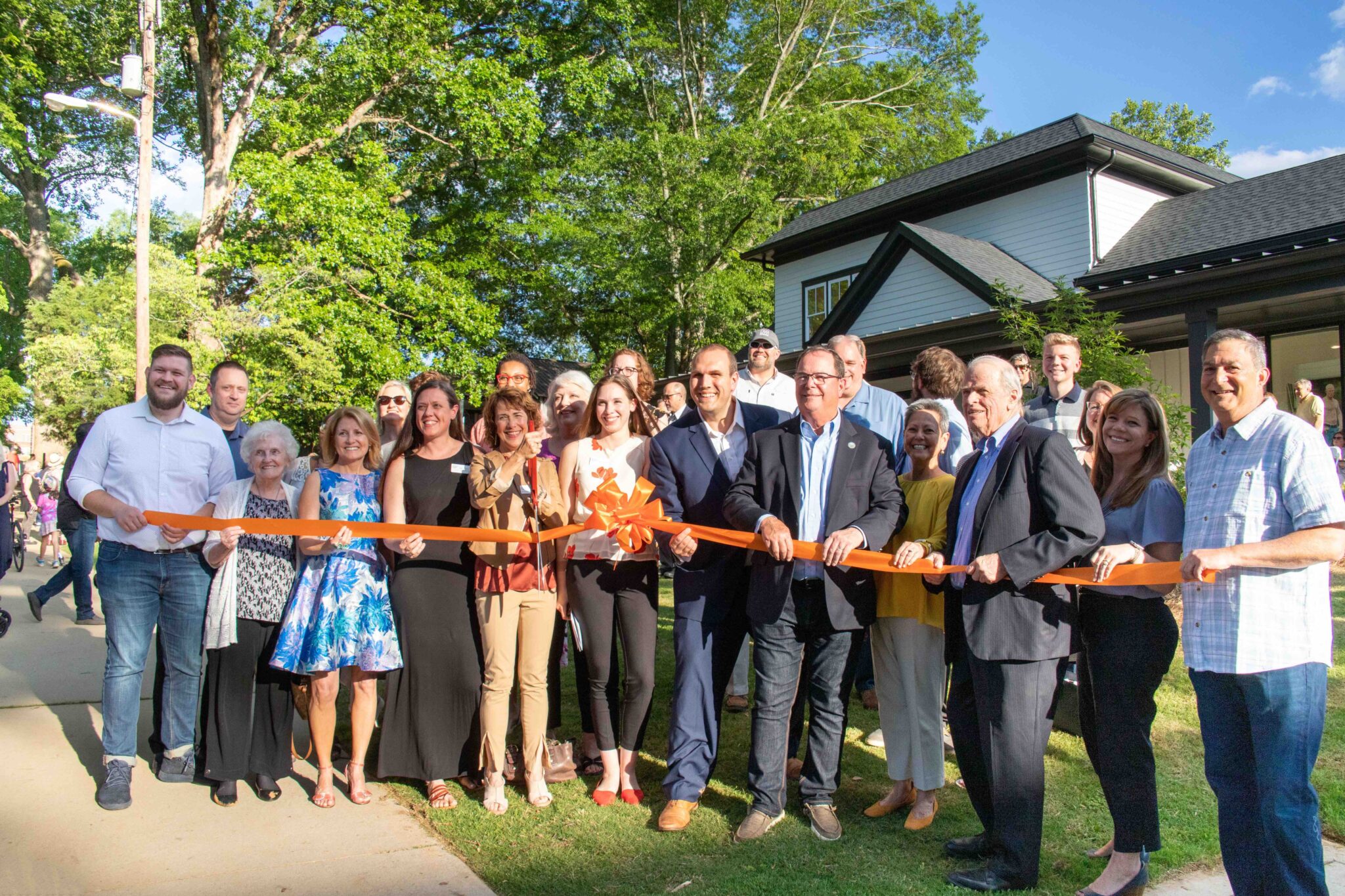 From left, Tim Cibene, Elm Street Cultural Arts Village board member and marketing committee chair, Juanita Hughes, studio manager Deborah Tidwell, Ann Litrel, Katie Caldwell, Elm Street Executive Director Christopher Brazelton, Woodstock Mayor Donnie Henriques, state Rep. Charlice Byrd, John Wieland, Melissa Cantrell, lead architect of CDH Partners, which designed the arts center, and Kenny Kligman, Reeves House chair, hold the ribbon fo the new Reeves House Visual Arts Center. Special - Rebecca Blackwell