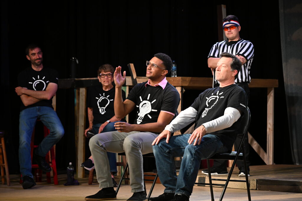 Five WIT! performers seated mid scene on the Woodstock Arts stage